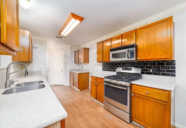 a kitchen with stainless steel appliances granite countertop a stove a sink and a microwave
