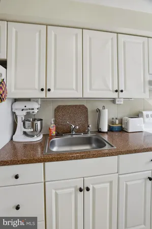 a kitchen with granite countertop white cabinets and white appliances