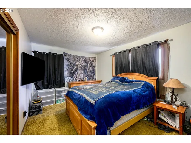 a bedroom with a bed and a flat screen tv