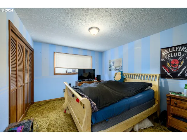 a bedroom with a bed and a flat screen tv