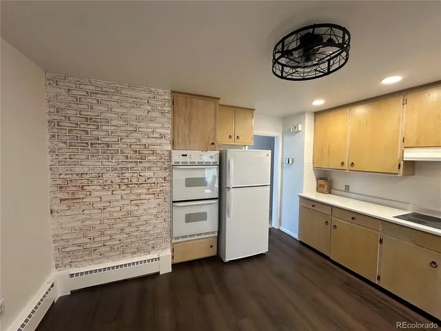 an empty room with wooden floor fireplace and windows