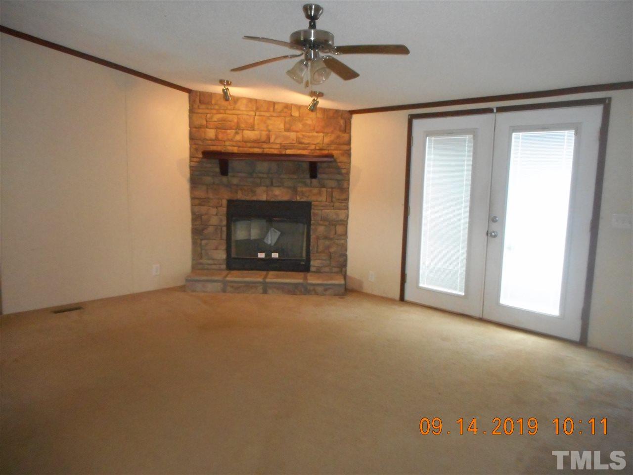1335 Thomas Store Road Timberlake, NC 27583 - Photo 4 of 13 a view of empty room with fireplace and fan