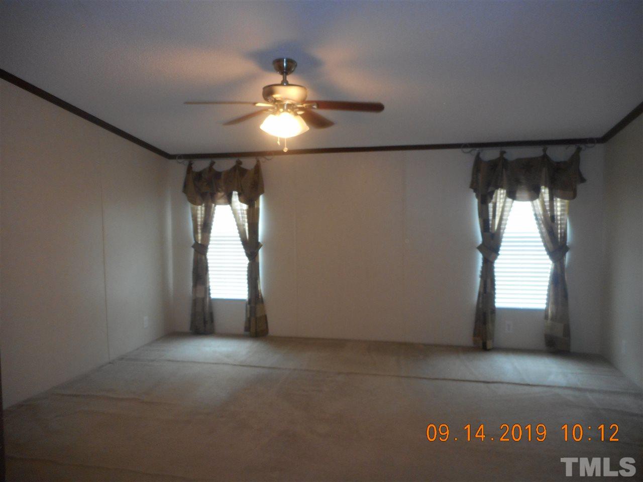 1335 Thomas Store Road Timberlake, NC 27583 - Photo 6 of 13 an empty room with windows and chandelier fan