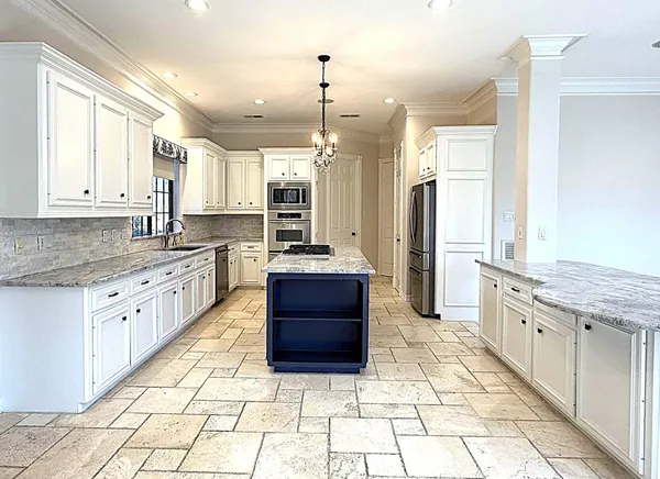 a large kitchen with stainless steel appliances lots of counter space and wooden floor