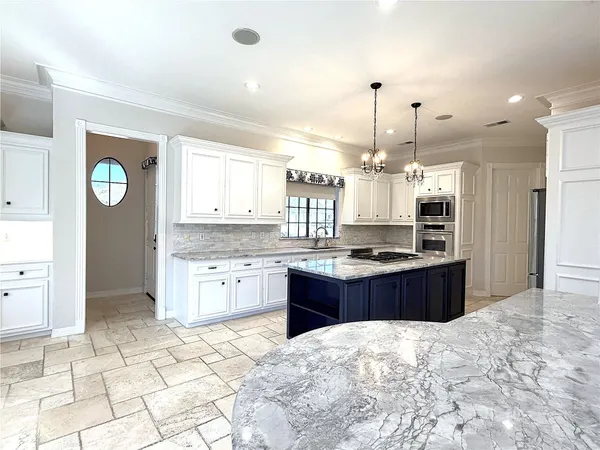 a kitchen with granite countertop a sink and stainless steel appliances