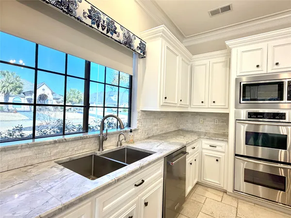 a large kitchen with stainless steel appliances granite countertop a stove and a refrigerator