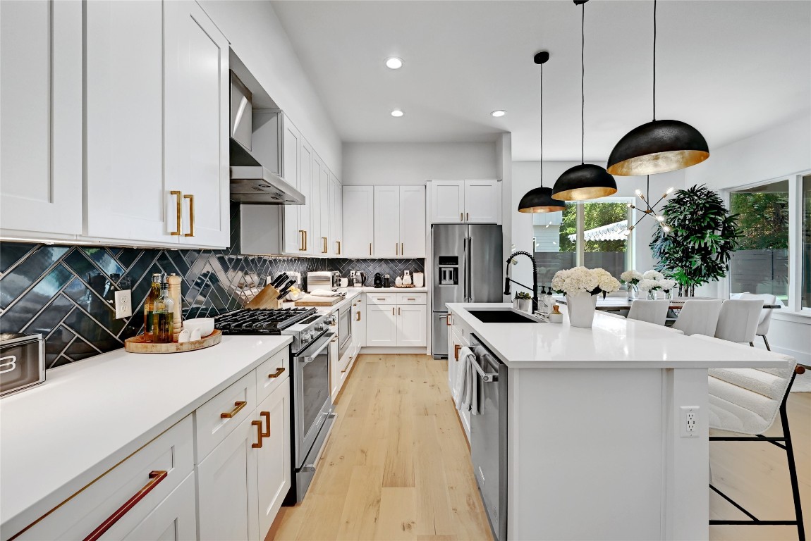 2909 Kuhlman Avenue, Unit 1 Austin, TX 78702 - Photo 14 of 40 a kitchen with kitchen island stainless steel appliances a sink a counter top space a large cabinets and a chandelier