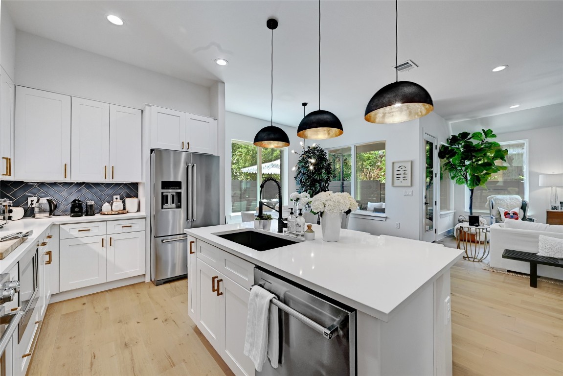 2909 Kuhlman Avenue, Unit 1 Austin, TX 78702 - Photo 15 of 40 a kitchen with stainless steel appliances a stove a sink a refrigerator and chandelier