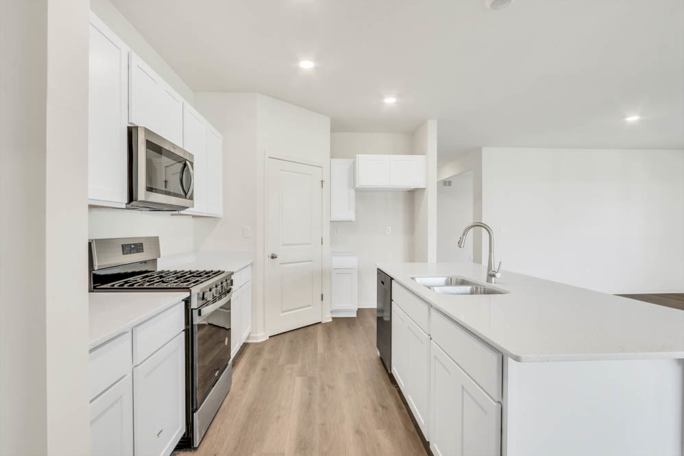 799 Mesa Lane Pingree Grove, IL 60140 - Photo 13 of 54 a kitchen with stainless steel appliances granite countertop a sink stove refrigerator and white cabinets with wooden floor