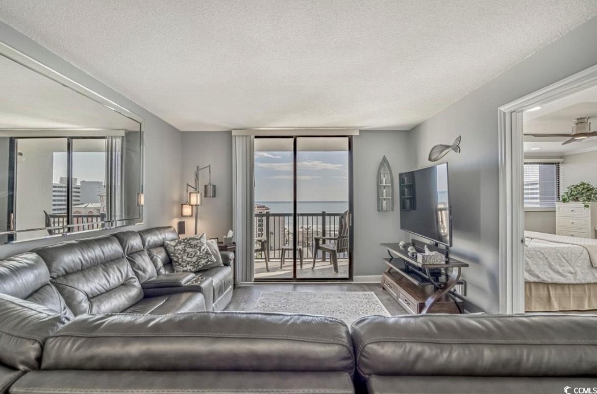 601 Mitchell Drive, Unit 1103 Myrtle Beach, SC 29577 - Photo 6 of 25 Living area with a textured ceiling and a wall of windows