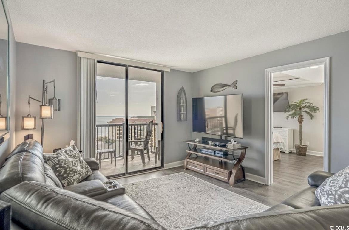 601 Mitchell Drive, Unit 1103 Myrtle Beach, SC 29577 - Photo 7 of 25 Living area with a textured ceiling, expansive windows, and wood finished floors