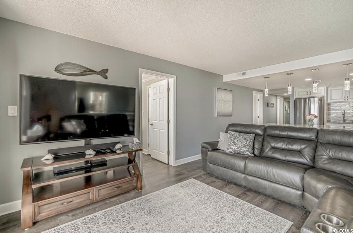 601 Mitchell Drive, Unit 1103 Myrtle Beach, SC 29577 - Photo 8 of 25 Living room featuring a textured ceiling and wood finished floors