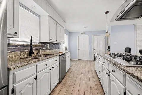 a kitchen with stainless steel appliances white cabinets and a refrigerator