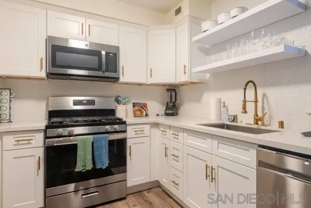 a kitchen with cabinets stainless steel appliances and a sink