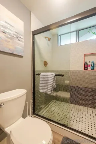a bathroom with a toilet and a shower