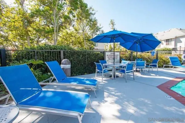 a view of backyard with seating space and wooden fence