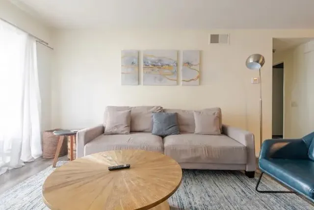 a living room with furniture and a wooden floor