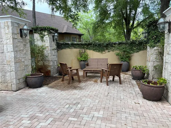 a view of a patio with table and chairs potted plants and a barbeque