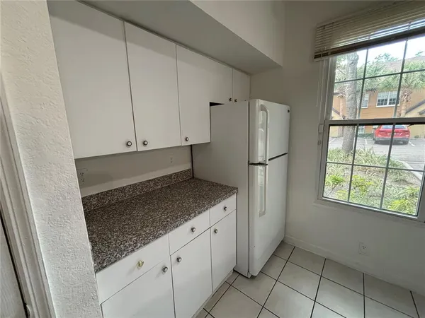 a kitchen with granite countertop a refrigerator and a sink