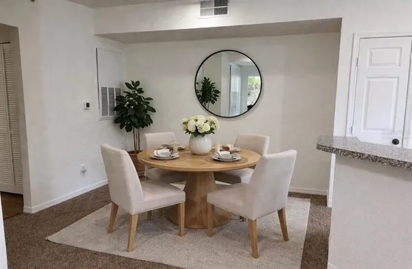 a dining room with furniture and mirror