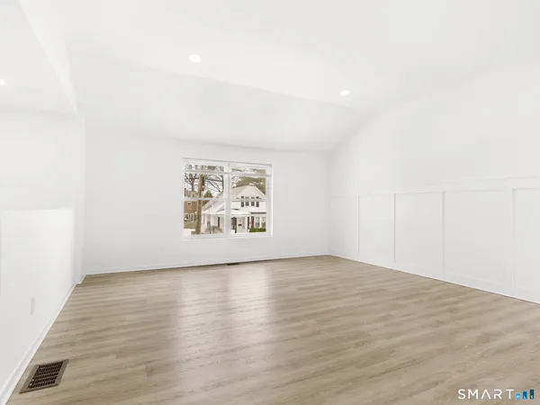 an empty room with wooden floor and window