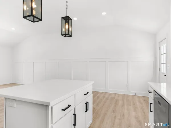 a kitchen with cabinets and wooden floor