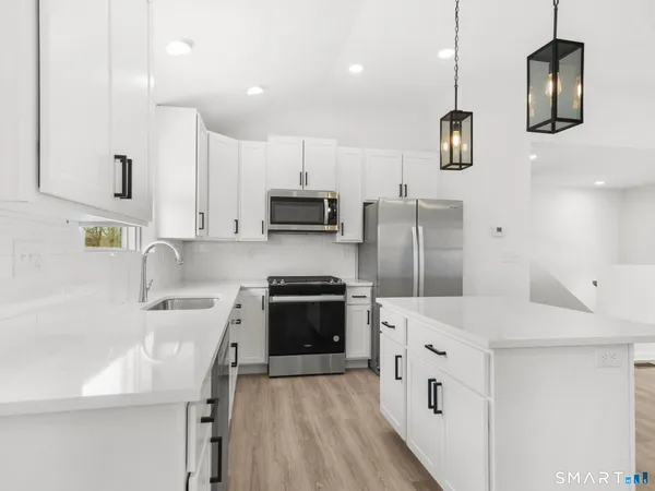 a kitchen with stainless steel appliances a stove sink microwave and refrigerator