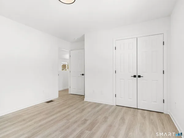 a view of an empty room with wooden floor