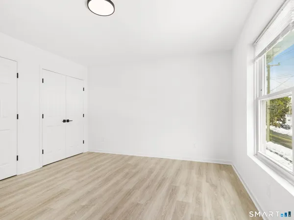 a view of a room with wooden floor and window