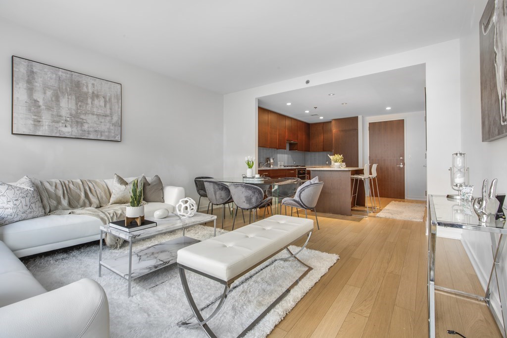 a living room with furniture and a view of kitchen