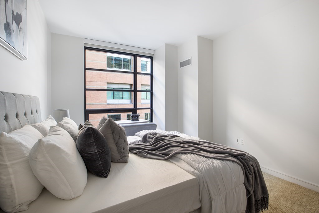 580 Washington Street, Unit 404 Boston, MA 02111 - Photo 15 of 34 a bedroom with a bed and a window