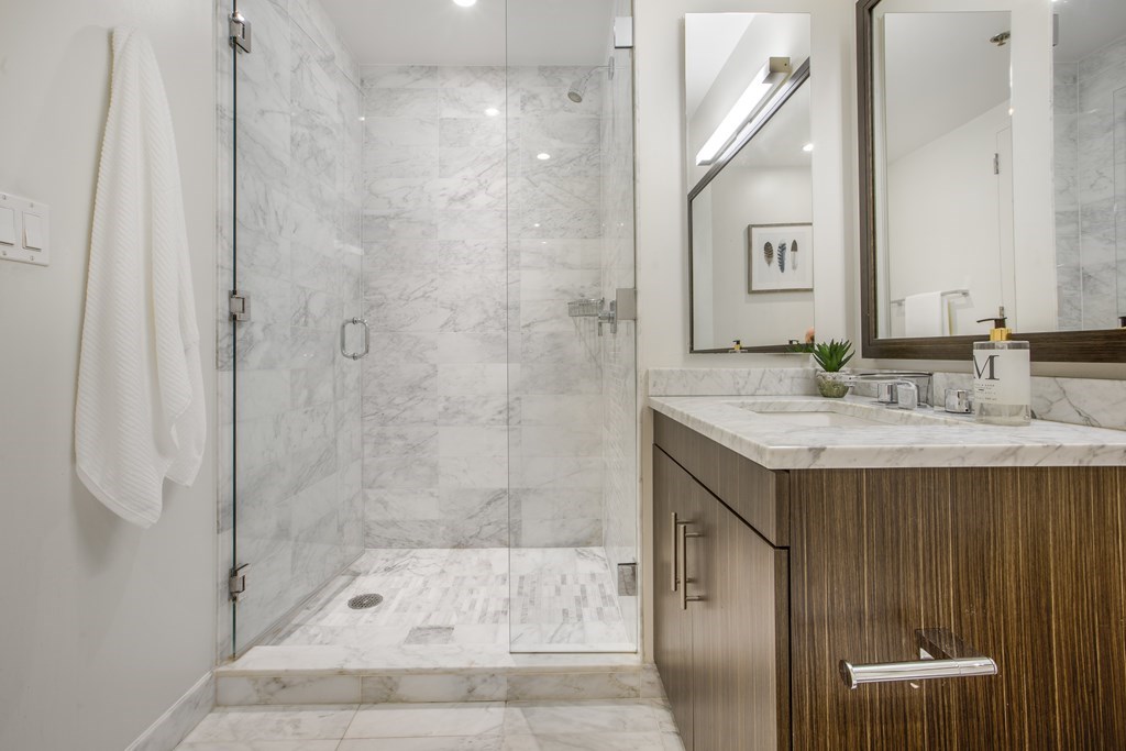 580 Washington Street, Unit 404 Boston, MA 02111 - Photo 19 of 34 a bathroom with a granite countertop sink a toilet and shower