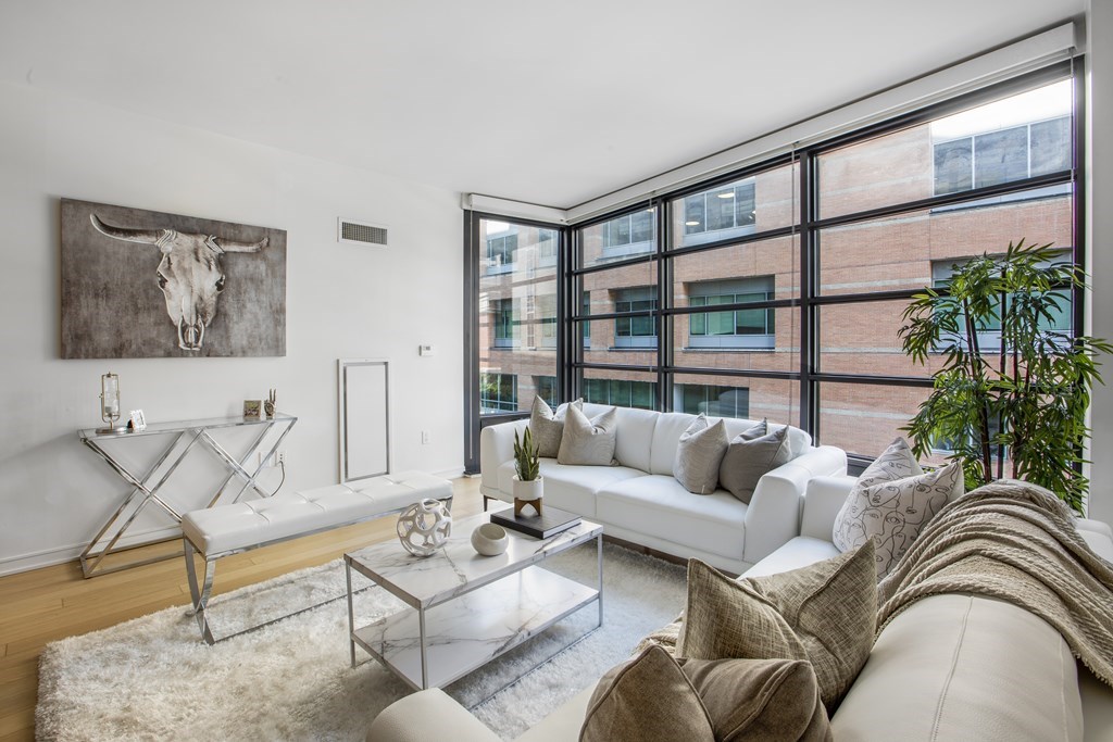 580 Washington Street, Unit 404 Boston, MA 02111 - Photo 6 of 34 a living room with furniture and a floor to ceiling window
