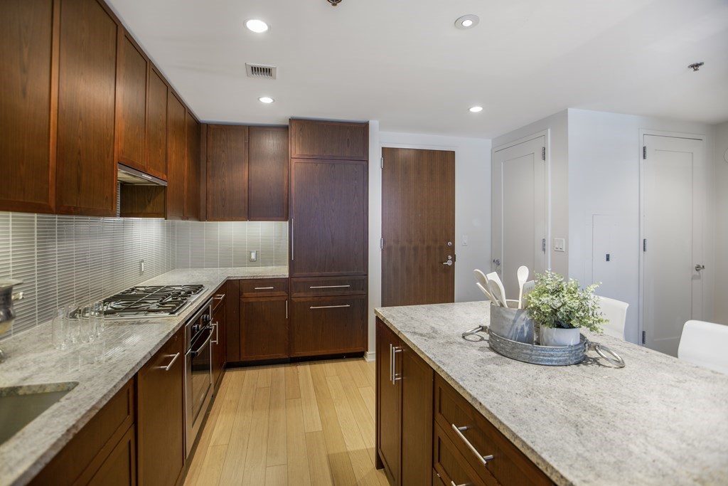 580 Washington Street, Unit 404 Boston, MA 02111 - Photo 10 of 34 a kitchen with kitchen island granite countertop stainless steel appliances a sink stove and refrigerator
