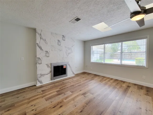 a view of empty room with wooden floor and fireplace