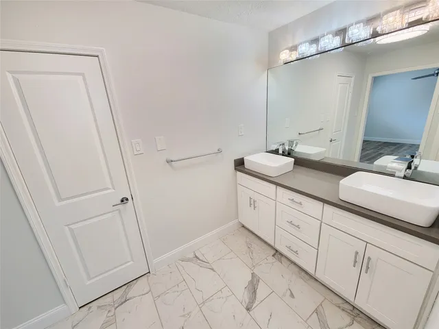 a spacious bathroom with a double vanity sink and mirror