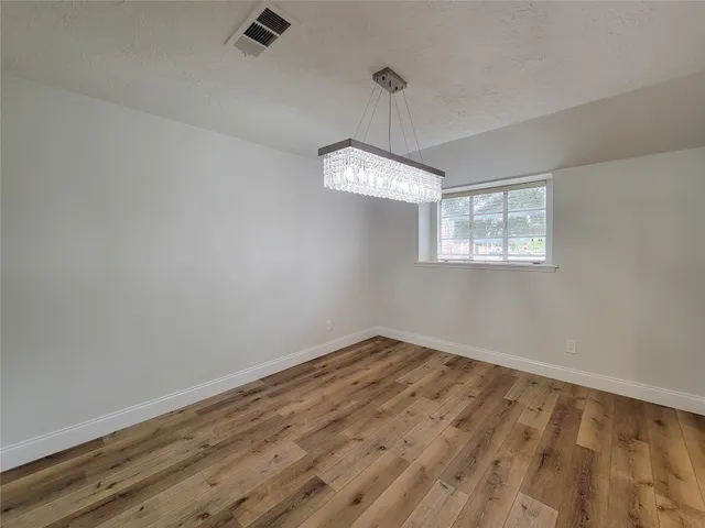 a view of an empty room with chandelier and a window