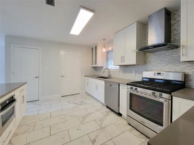 a kitchen with cabinets stainless steel appliances and a sink