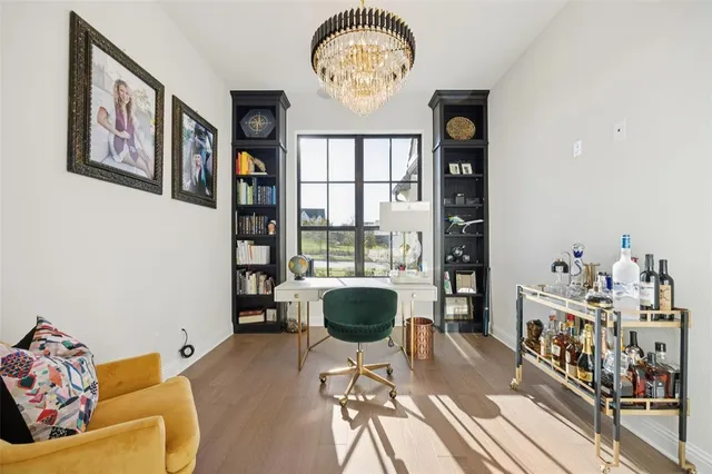 a living room with furniture a chandelier and a large window
