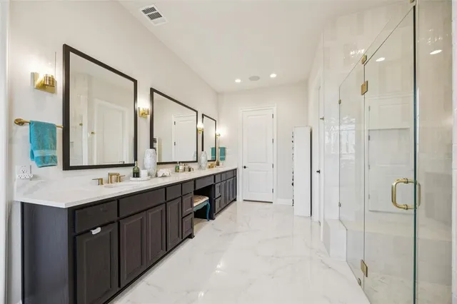 a bathroom with a double vanity sink mirror and shower