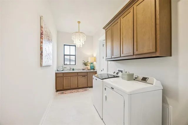 a utility room with cabinets washer and dryer