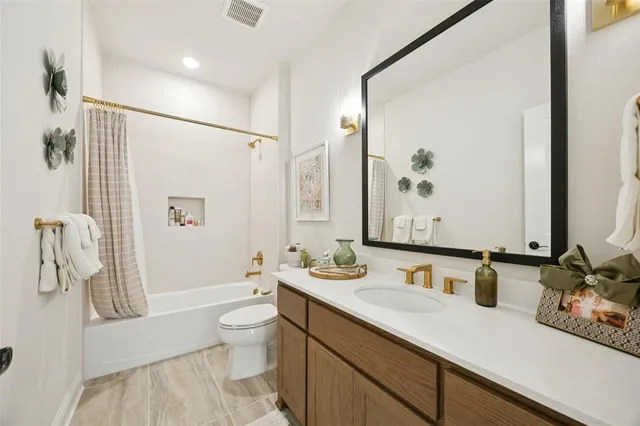 a bathroom with a granite countertop sink a toilet a mirror and shower
