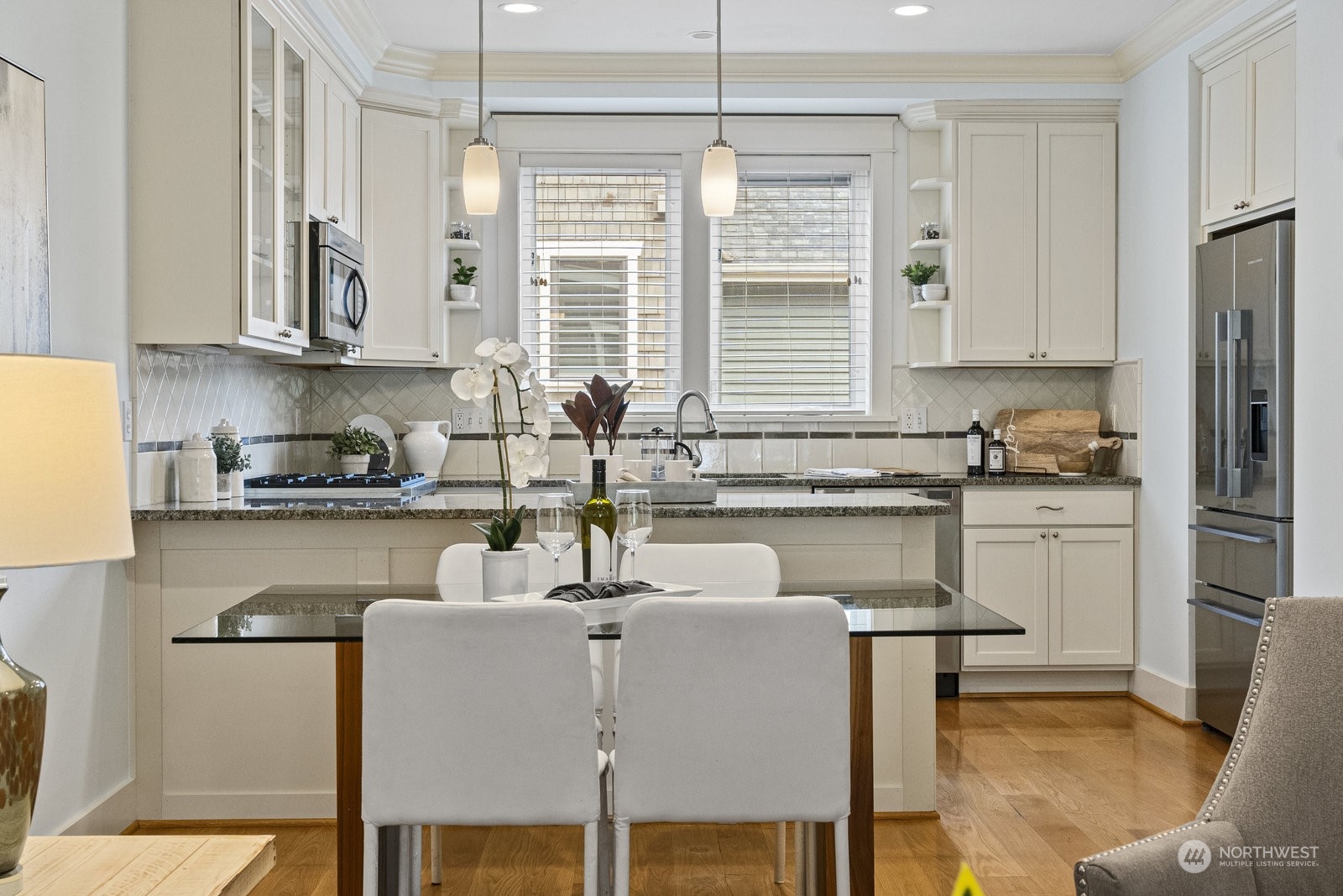 16 West Etruria Street Seattle, WA 98119 - Photo 6 of 40 a kitchen with stainless steel appliances granite countertop a refrigerator a sink a stove and white cabinets with wooden floor