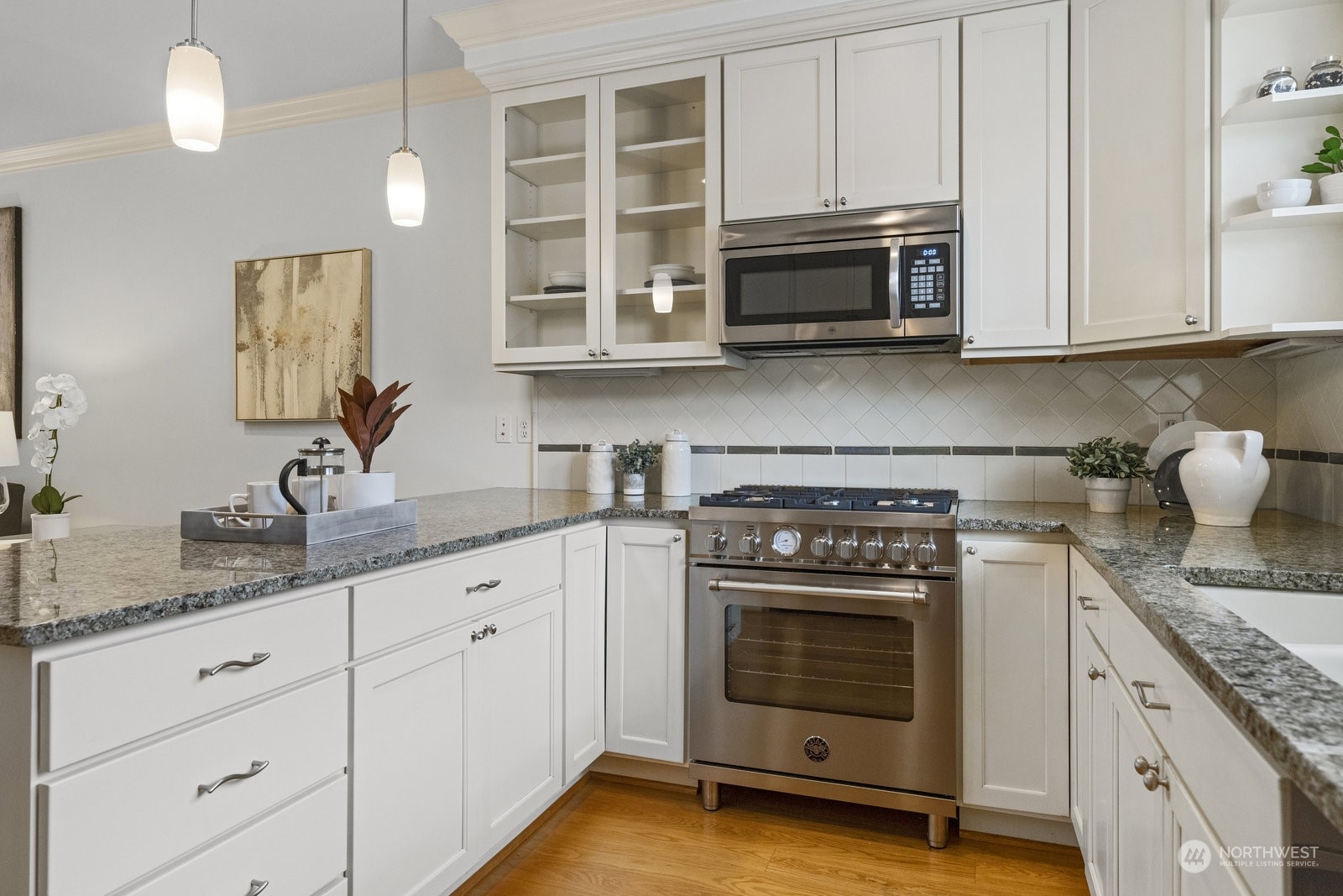 16 West Etruria Street Seattle, WA 98119 - Photo 10 of 40 a kitchen with granite countertop white cabinets and stainless steel appliances