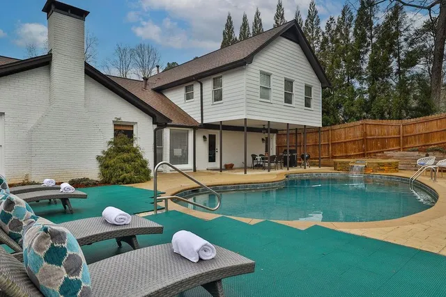 a view of house with swimming pool yard slide and outdoor seating