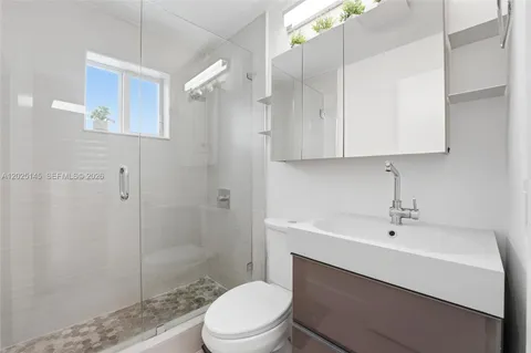 a bathroom with a sink a toilet and shower