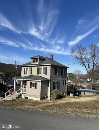 a view of a white house with a large road next to a road