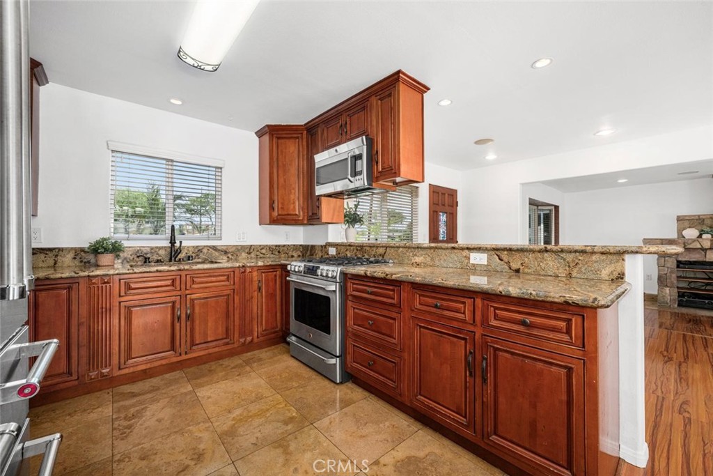 1238 North Studebaker Road Long Beach, CA 90815 - Photo 14 of 47 a large kitchen with granite countertop a sink and a stove