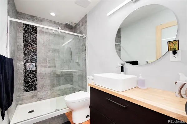 a bathroom with a sink a toilet and shower