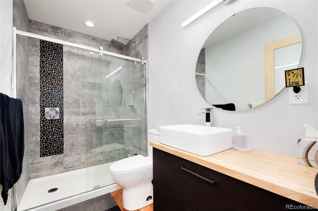 a bathroom with a sink a toilet and shower